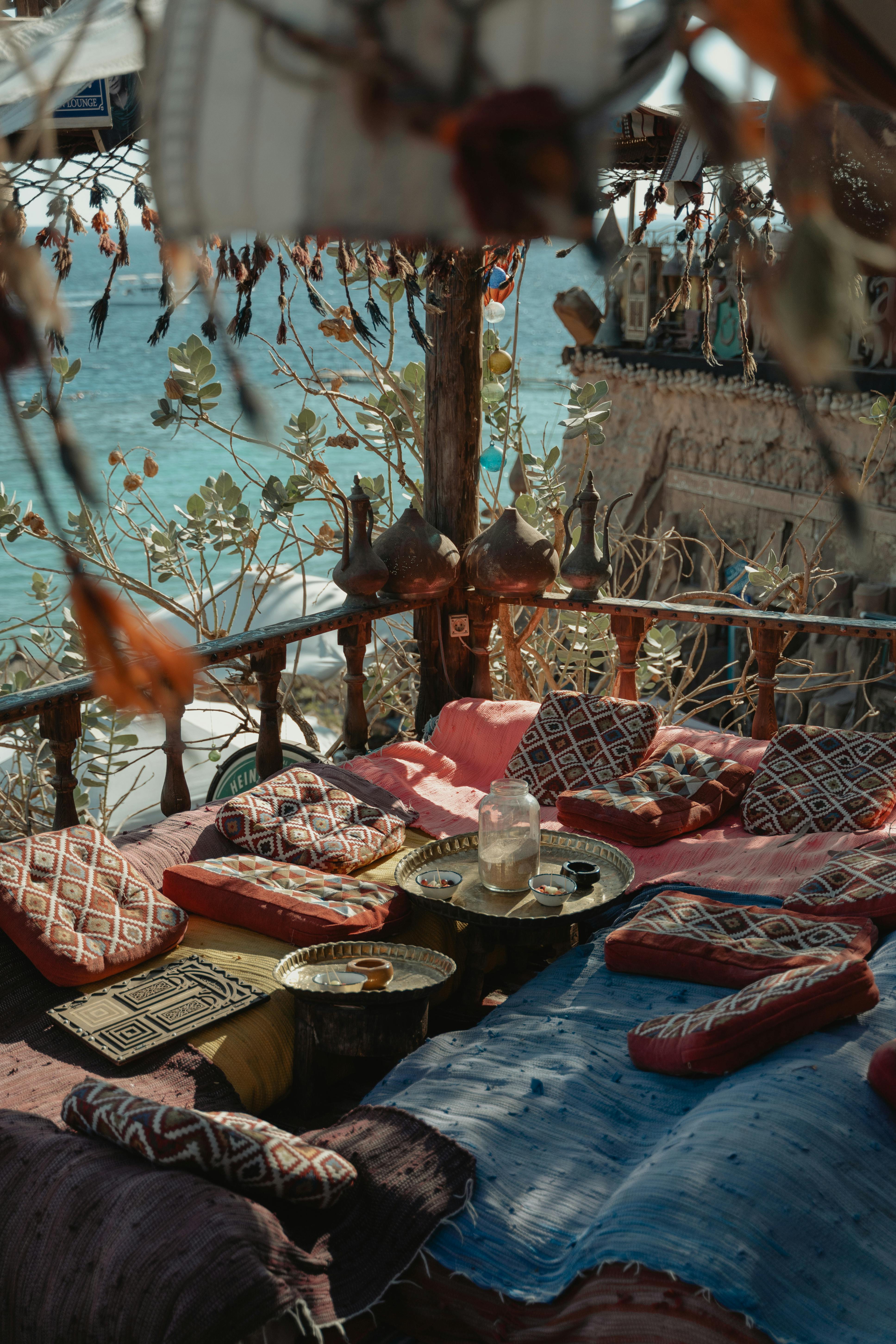 迷人的波西米亚户外休息区，配有俯瞰大海的彩色靠垫，非常适合放松