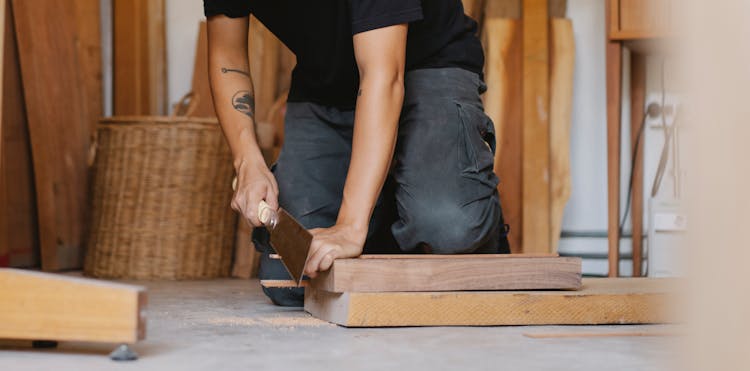 Man Cutting Piece Of Wooden Plank With Planer