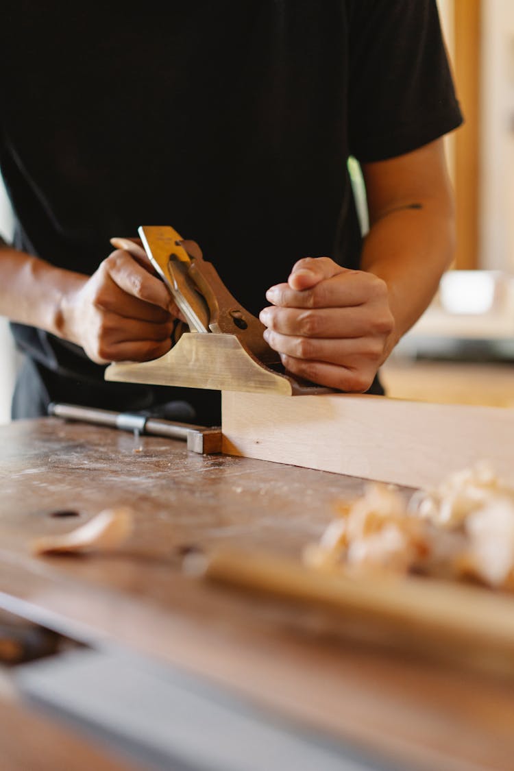 Man Working With Wooden Plank And Planer