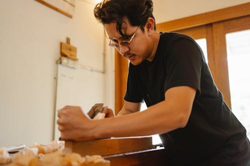 Focused ethnic joiner planing wood plank