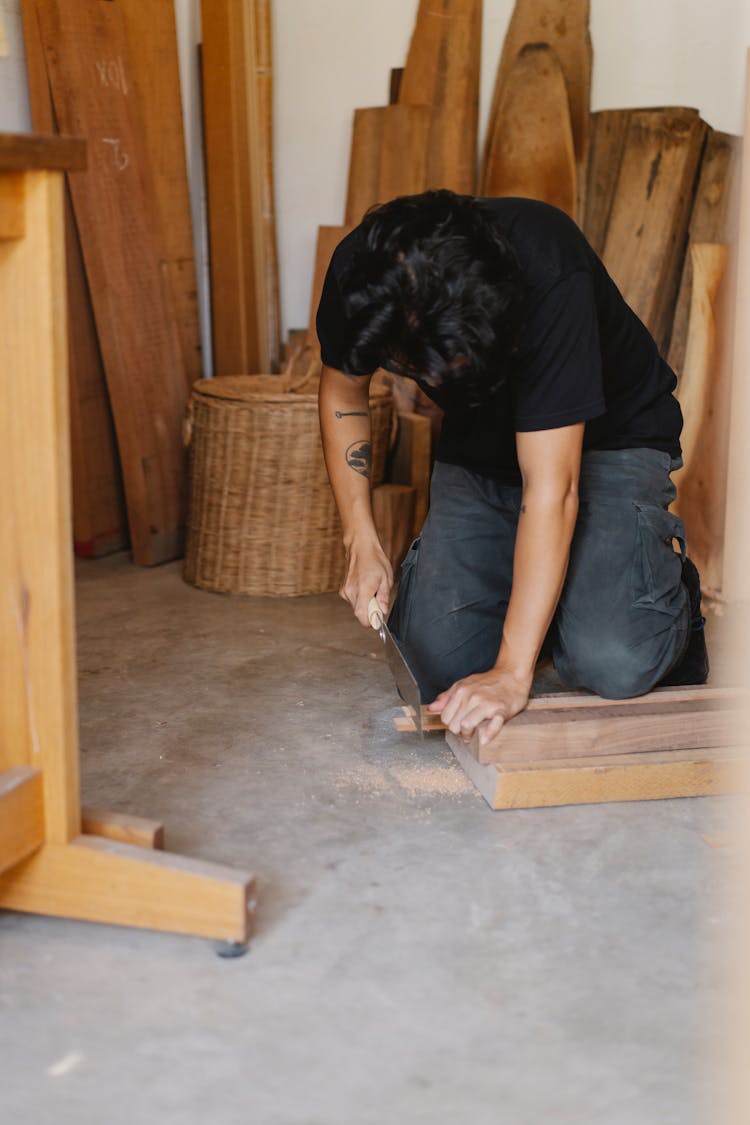 Focused Joiner Sawing Piece Of Wood Plank In Workshop