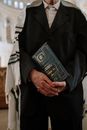 Man in Black Suit Jacket Holding Black Book