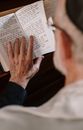 Person in Blue Long Sleeve Shirt Holding White Book