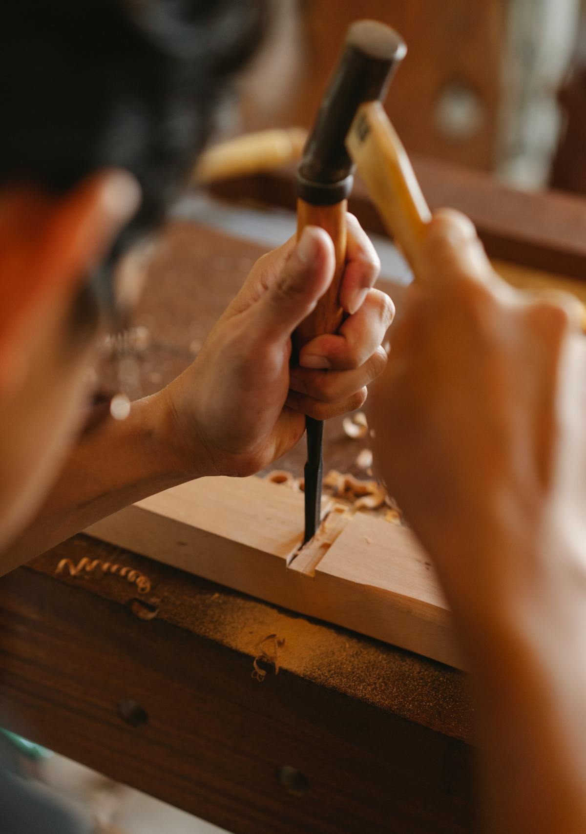Handwerker bei feiner Holzarbeit mit Stechbeitel