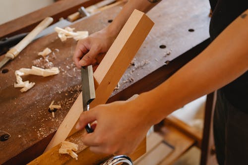 Master shaping wooden board with sharp tool