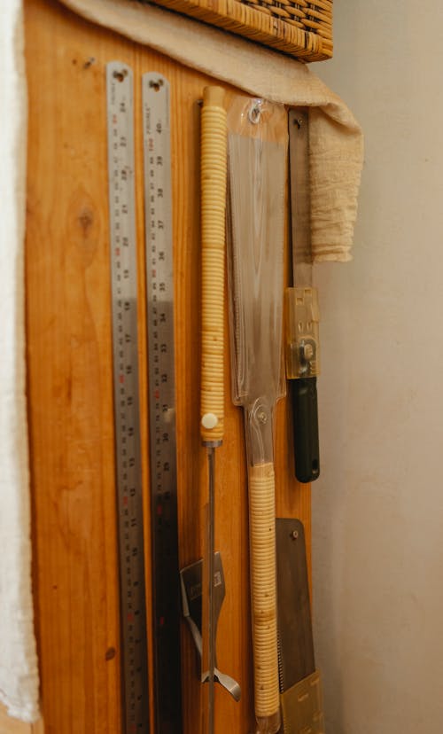 Free Set of various instruments for carpentry including rulers hanging with saws on wooden wall in joinery workshop Stock Photo
