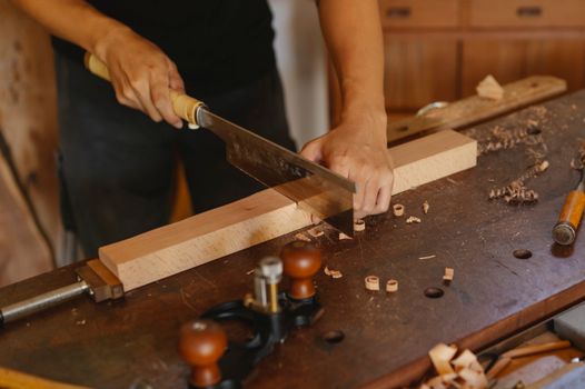 Craftsman cutting wooden detail with saw