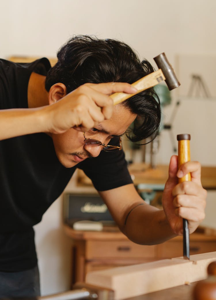 Artisan Shaping Wooden Plank With Hammer And Chisel