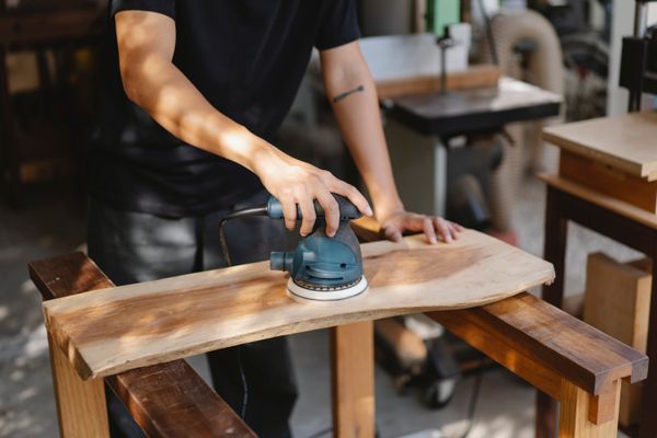 Craftsman sanding and refinishing a wood surface for EverReady Services