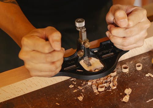 Close Up Photo of Craftsman Crafting Wooden Plank 