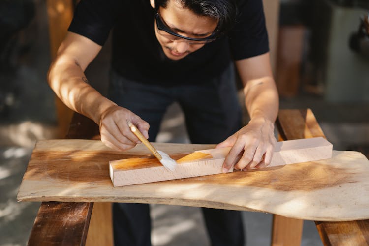 Craftsman Applying Varnish On Wooden Detail