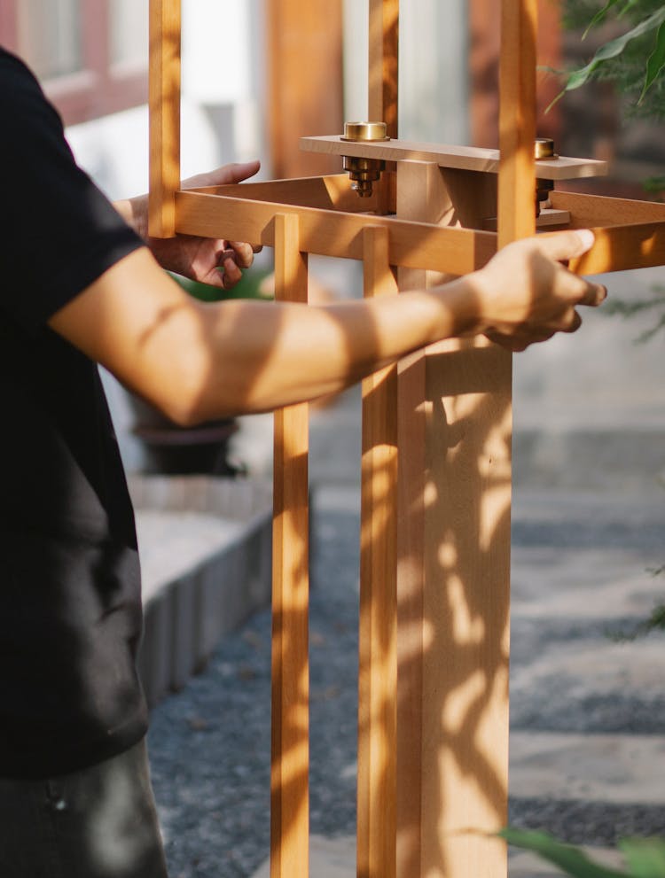 Man Fixing Wooden Construction In Yard