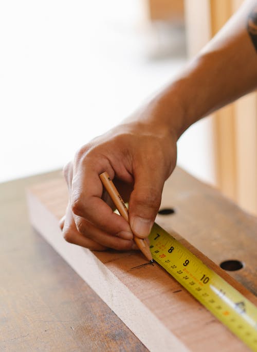 Crop craftsman measuring wooden plank