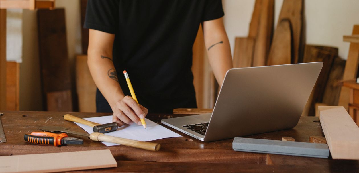 Free Crop man working on laptop in joinery Stock Photo
