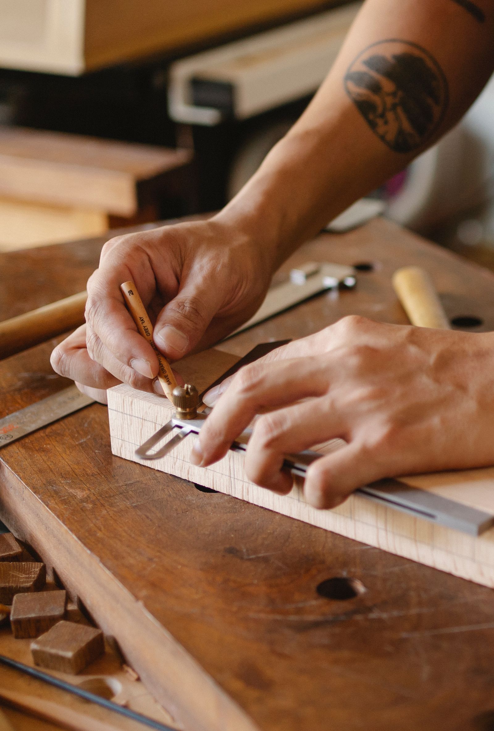A craftsman carefully measuring a piece of wood on a workbench