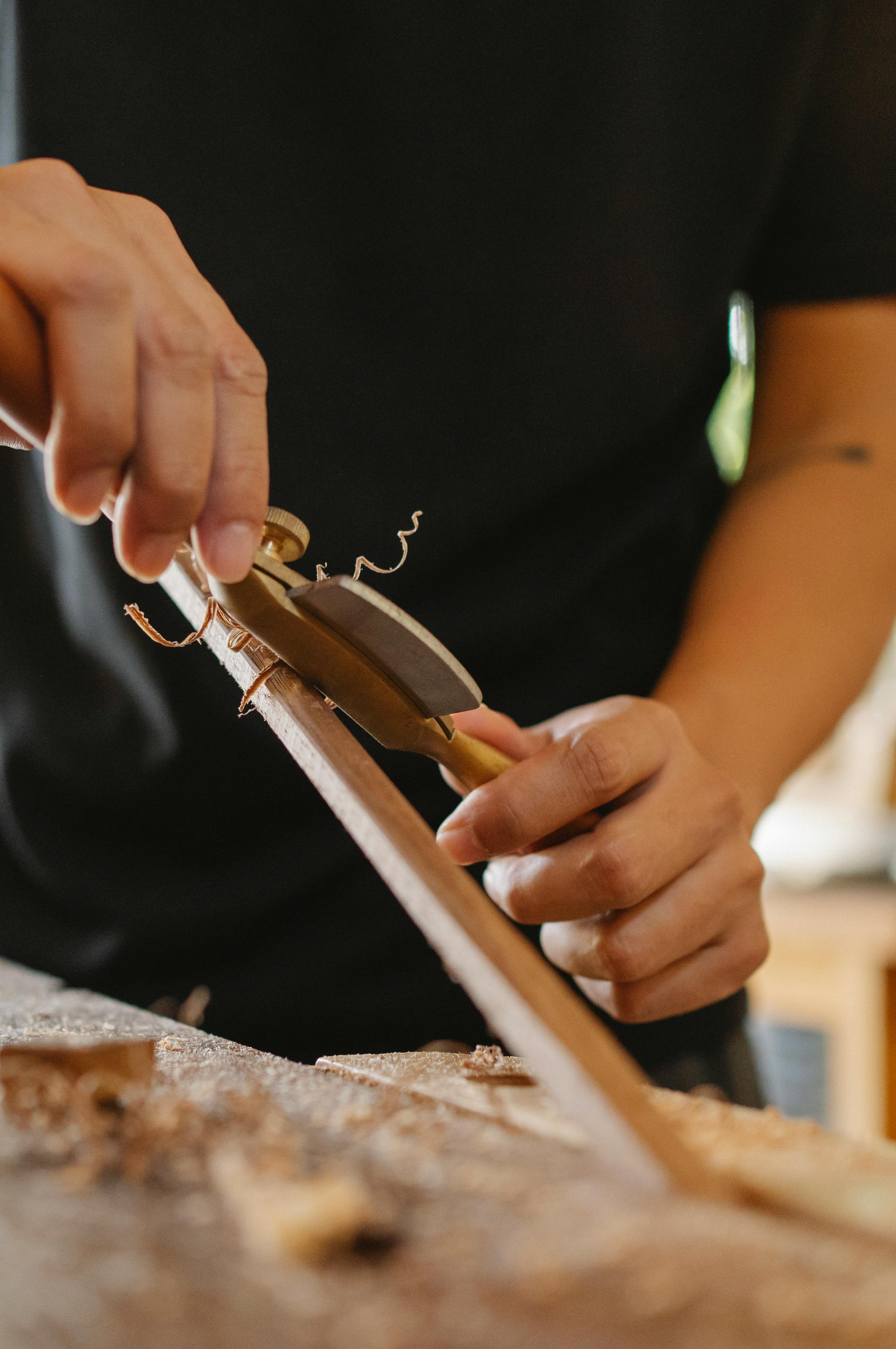 anonymous woodworker using spokeshave in workshop