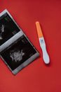 An Ultrasound and a Pregnancy Test on a Red Surface