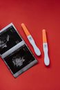 An Ultrasound and Pregnancy Tests on a Red Surface