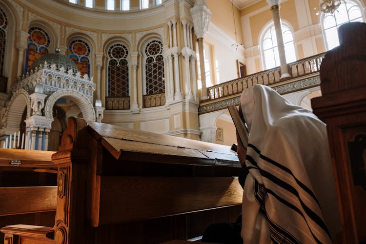 A Person Wearing A Tallit In A Synagogue