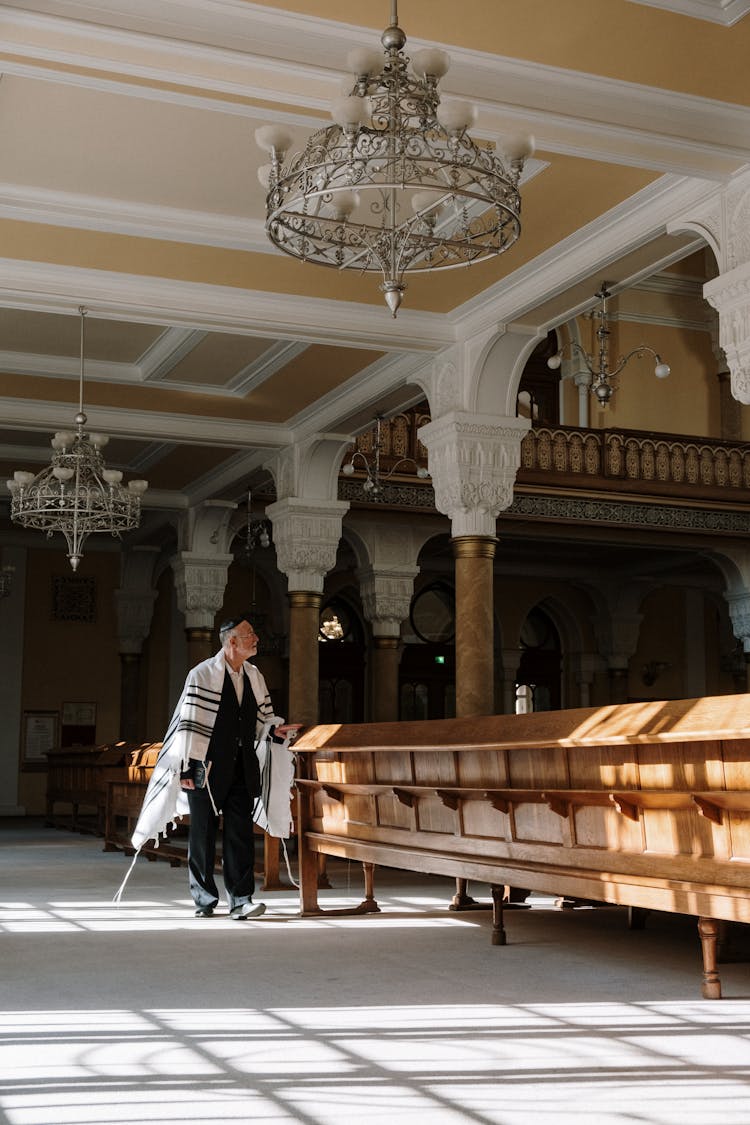 A Man In A Tallit Walking In A Synagogue