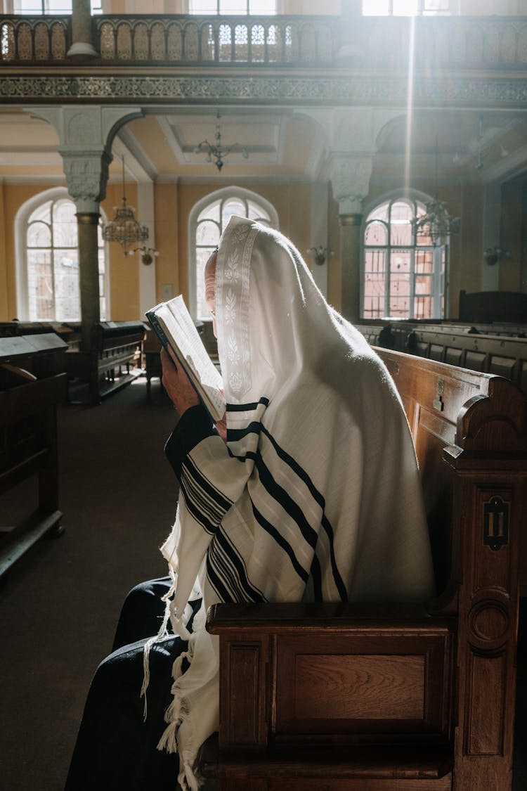 A Person In Tallit While Reading A Book
