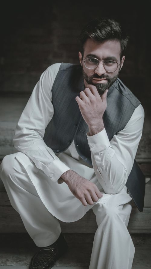 Free Portrait of a bearded man in a traditional outfit with a thoughtful pose indoors. Stock Photo