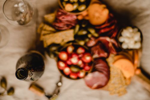 Free A vibrant charcuterie board filled with meats, cheeses, and olives paired with a bottle of red wine. Stock Photo