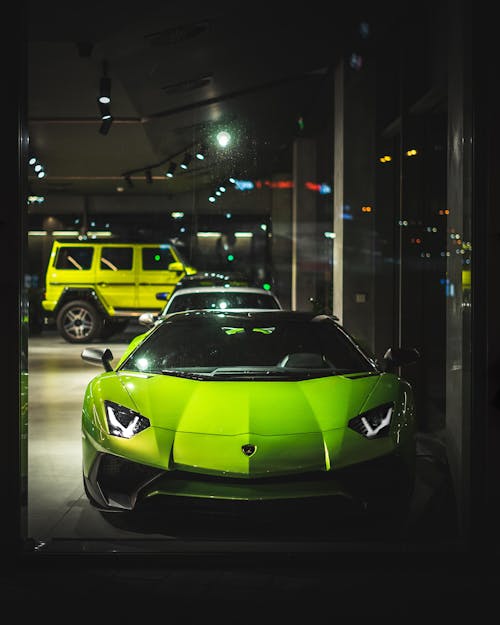 Free Green Luxury Car Parked in a Car Dealership Building Stock Photo
