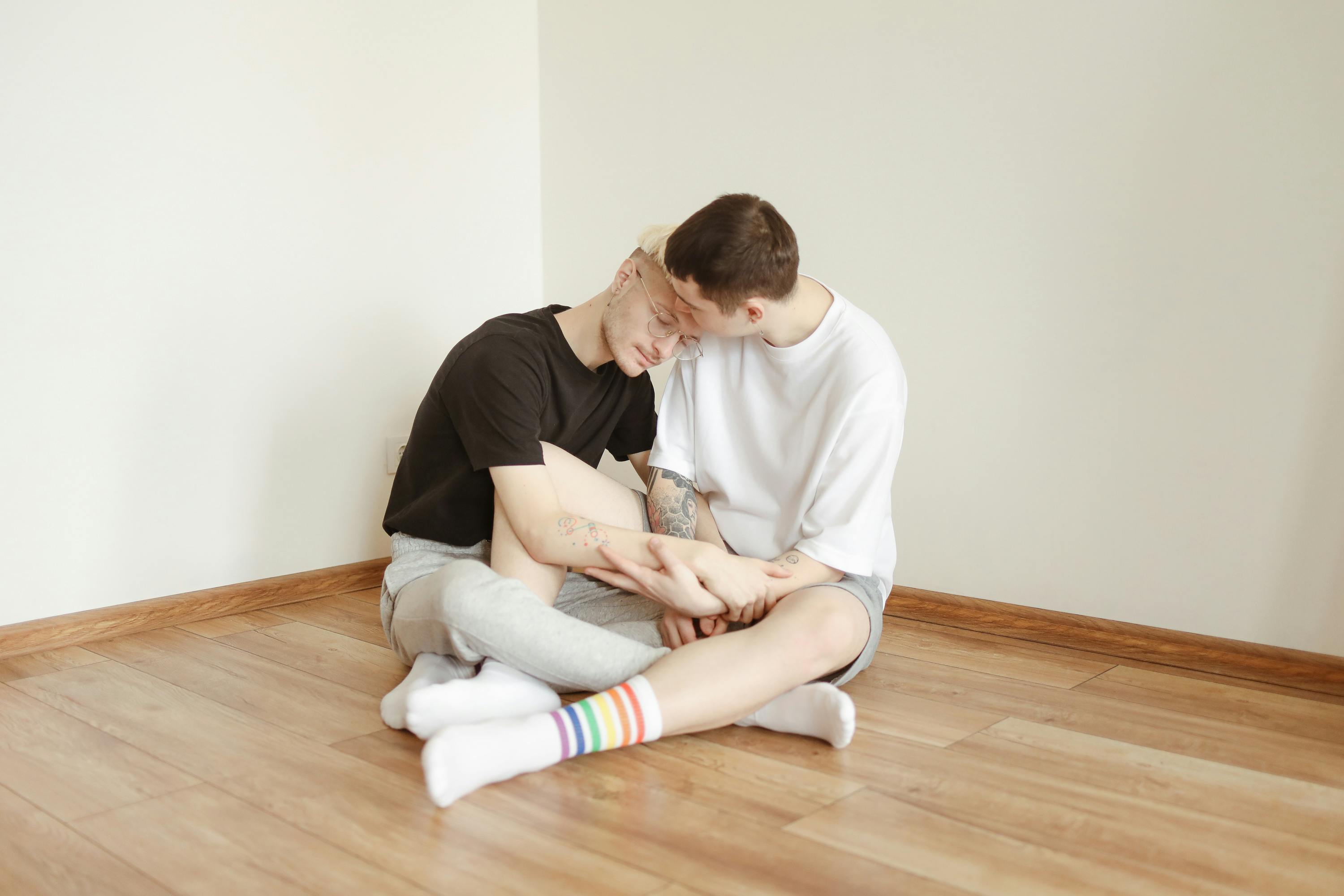 couple holding hands sitting on a wooden floor