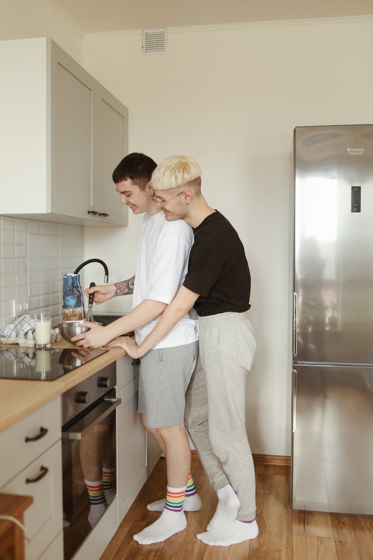 A Couple Cooking At The Kitchen