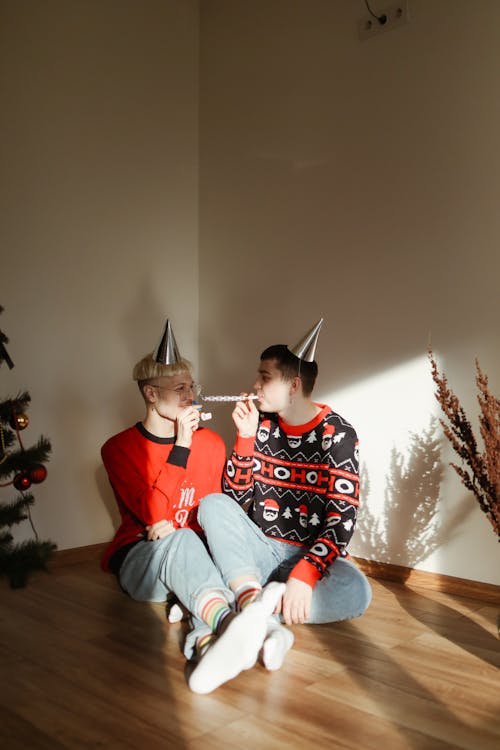 A Couple Sitting Beside the Christmas Tree
