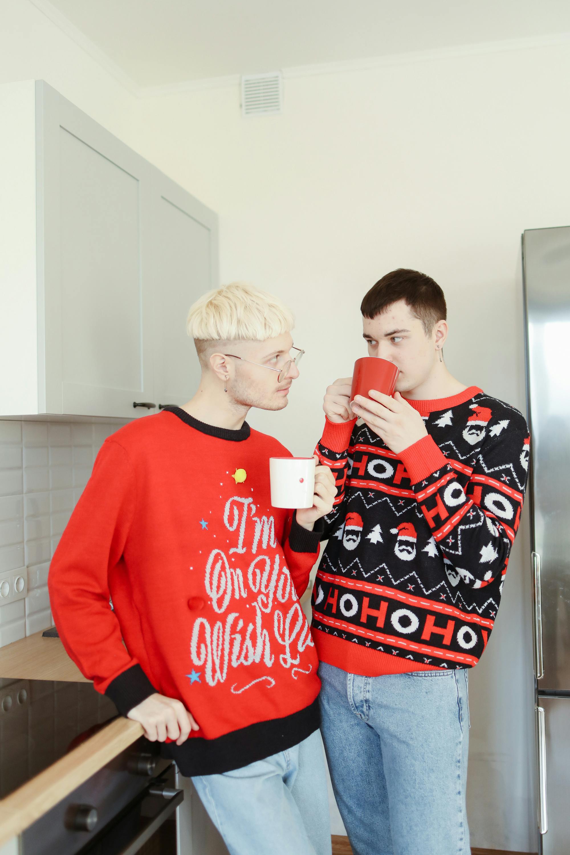 two men standing in the kitchen drinking coffee