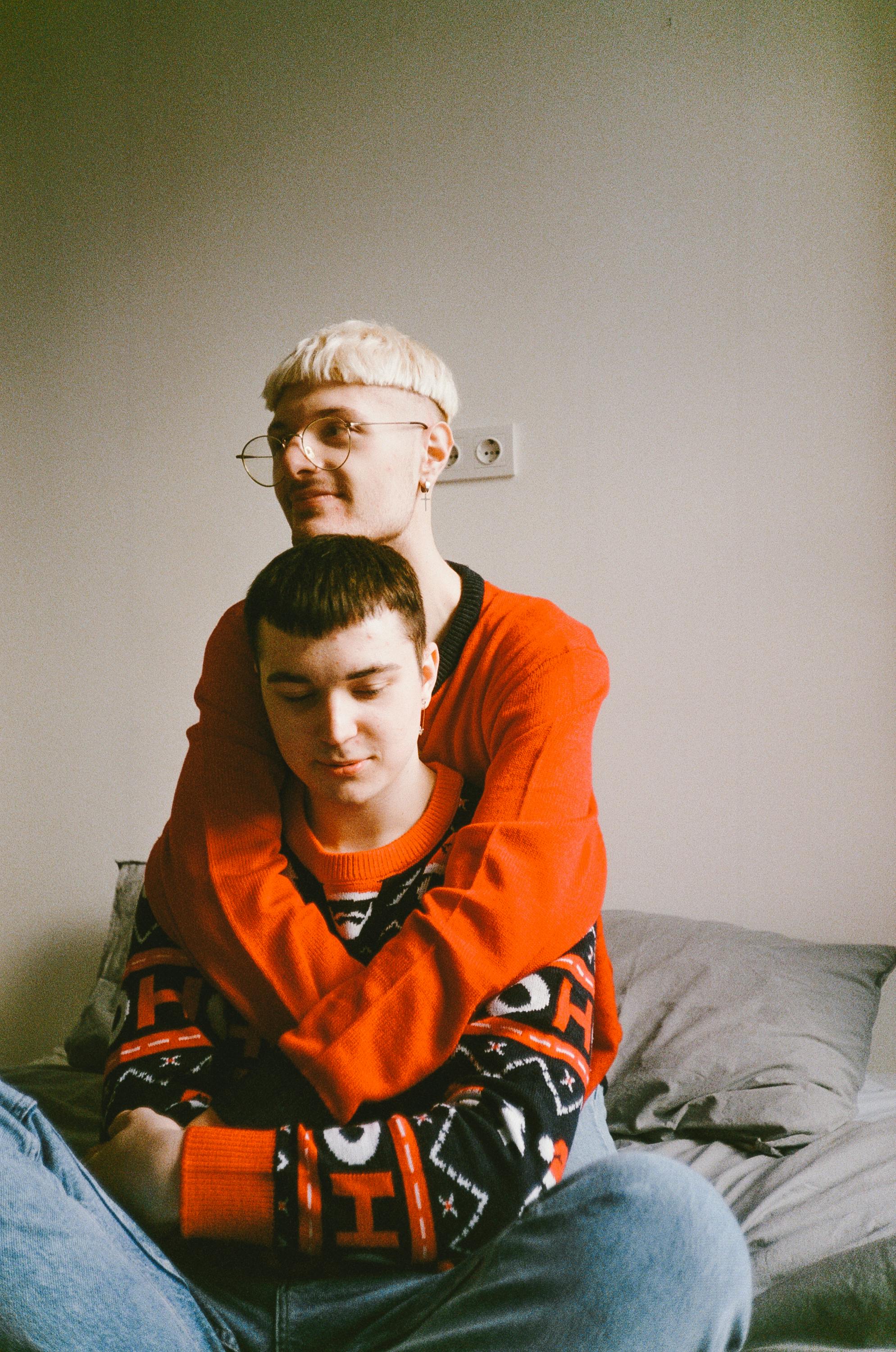 woman in orange hoodie sitting on bed