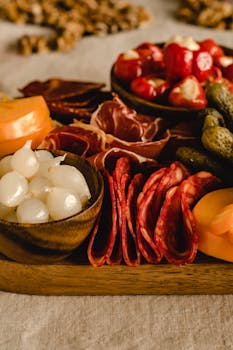 Delicious charcuterie board featuring salami, pickles, onions, and peppers in a cozy, rustic setting.