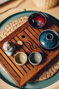 Beautifully arranged ceramic cups and wooden tray for a traditional tea ceremony.
