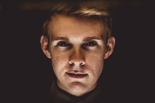 Free Dramatic close-up portrait highlighting the intense gaze of a young man. Stock Photo