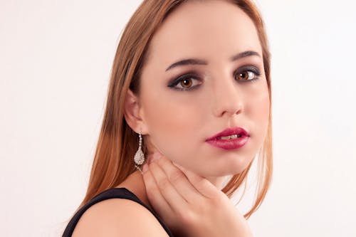 Free Brown Eyed Woman Posing with her Hand Touching her Neck  Stock Photo