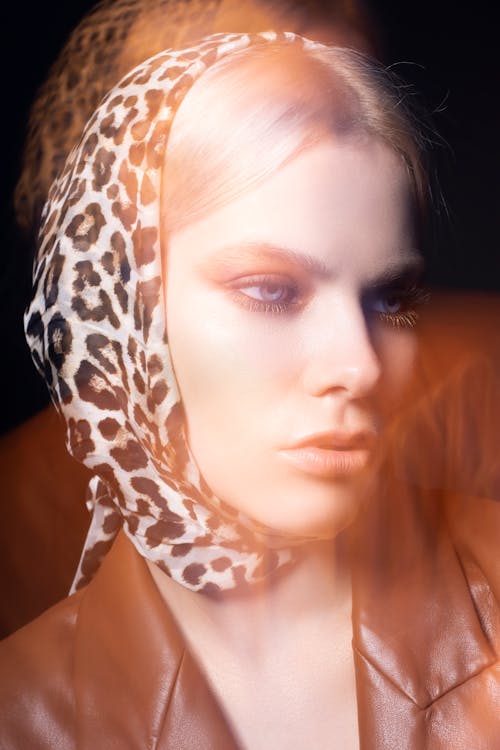 Young female on trendy outfit looking away on on black background of studio