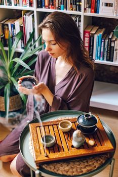 A woman enjoying a peaceful tea ceremony at home, embracing tradition.