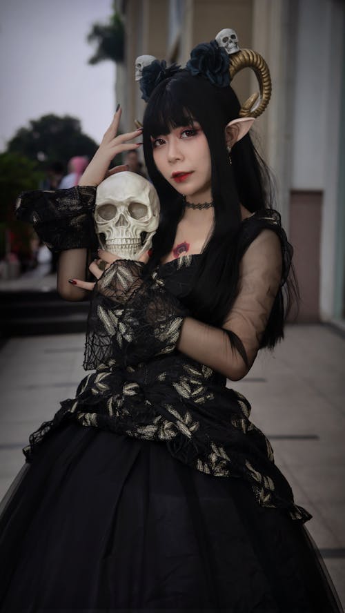 Woman in Black Gown Holding a White Skull 