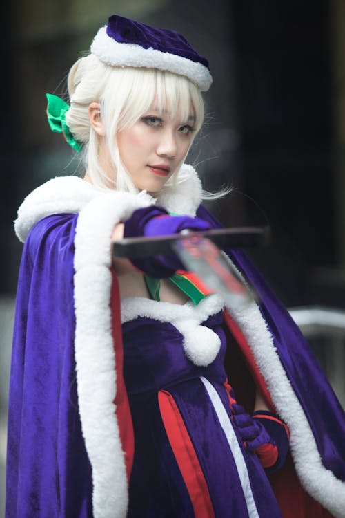 A Cosplayer in Purple Costume Posing at the Camera