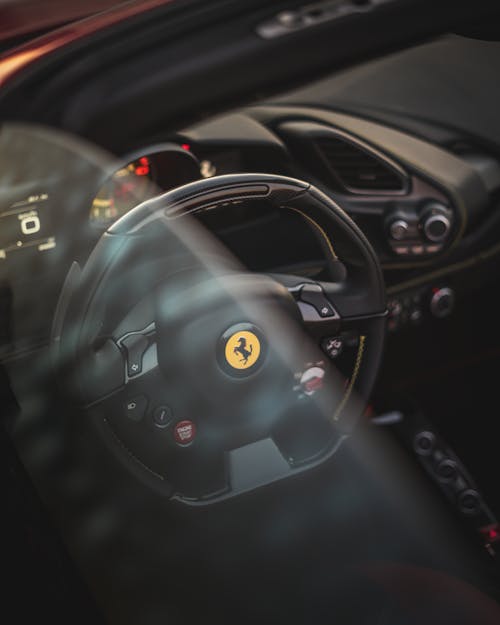 Through window of dashboard of prestige automobile with sport steering wheel and speedometer