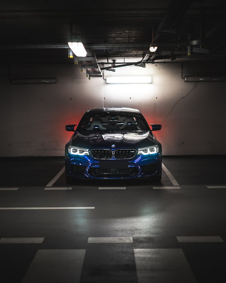 Luxury Shiny Blue Car Under Bright Illumination On Parking Lot