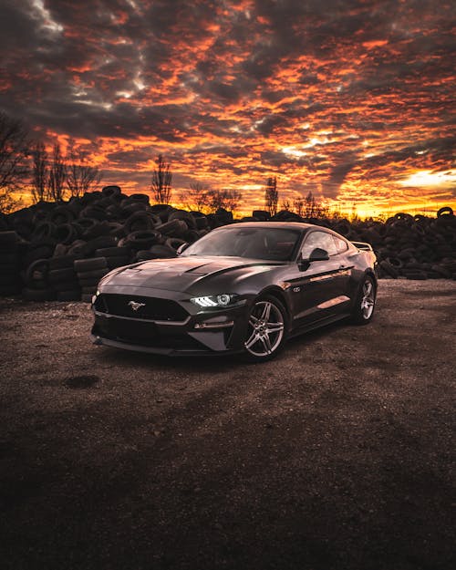 Modern luxury sparkling car under bright cloudy sky in sunset