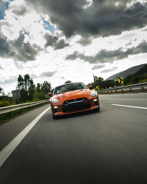 Free Contemporary luxury automobile driving fast on asphalt road under sunny cloudy bright sky in summer Stock Photo