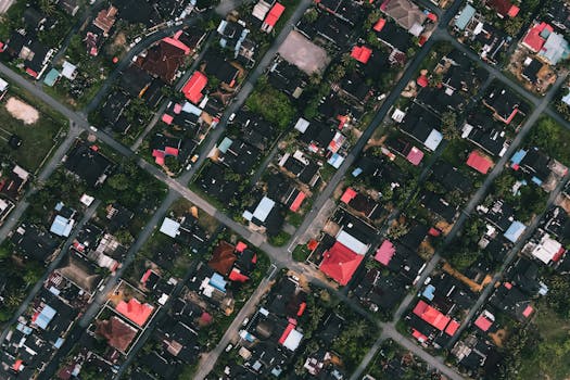 Drone view of residential district with various houses and green trees in town