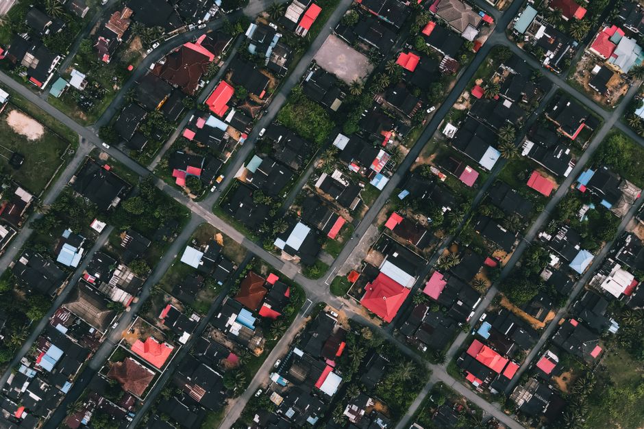 Drone view of residential district with various houses and green trees in town