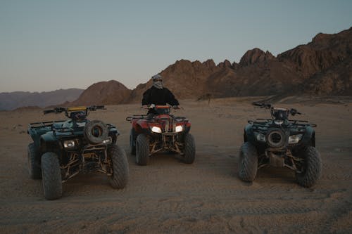 A Person Sitting on an ATV in a Desert