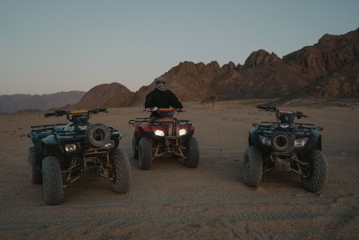 Trois quads alignés devant les montagnes