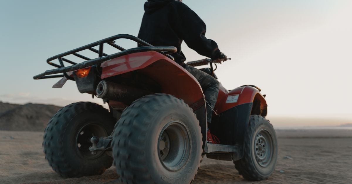 Man riding a quad bike in the desert at dawn, capturing adventure and thrill.